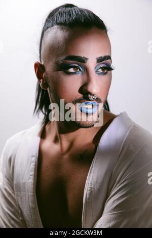 Porträt einer glamourösen Transgender bärtigen Frau in raffiniertem Make Blick weg vor neutralem Hintergrund Stockfoto