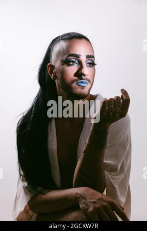 Porträt einer glamourösen Transgender bärtigen Frau in raffiniertem Make Blick weg vor neutralem Hintergrund Stockfoto