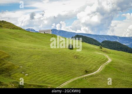 Fantastische Landschaft mit Pfad, der zu einer Hütte vom Pass Fittanze Di Sega aus gesehen ansteigt, in Lessinia, in der Nähe von Verona in Italien Stockfoto