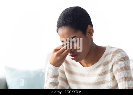 Stresskonzept. Verärgert Afroamerikanische Frau Reibt Nase Brücke, Nahaufnahme Schuss Stockfoto