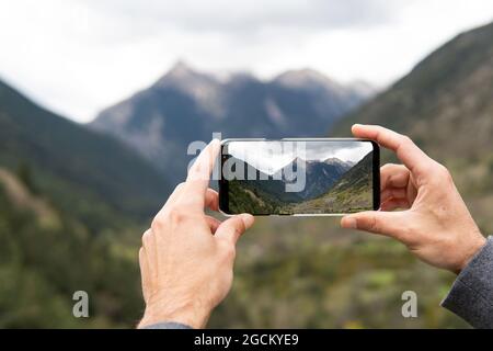 Crop unkenntlich Forscher fotografieren die Pyrenäen Bergkette auf dem Handy während des Trekkings Stockfoto