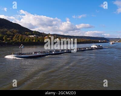 Enormer Handelsschiff, der in Deutschland entlang des rheins bewegt wird, gefolgt von einem Flusskreuzfahrtschiff Stockfoto