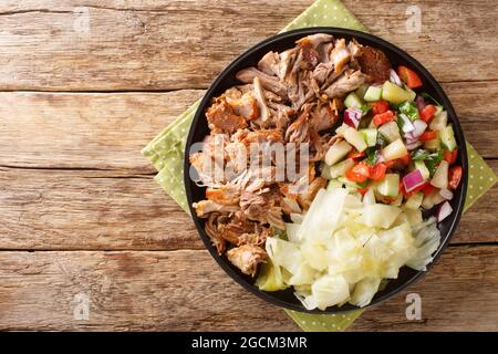 Kalua Schweinefleisch hawaiianische Speisen langsam gekocht und serviert mit gedünstetem Kohl und frischem Salat close-up in einem Teller auf dem Tisch. Horizontale Ansicht von oben Stockfoto