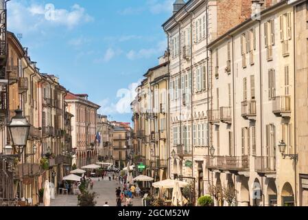 CUNEO, PIEMONT, ITALIEN - 2. AUGUST 2021: Via Roma mit dem Rathaus und den historischen bunten Gebäuden Stockfoto