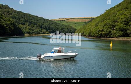 Looe, Cornwall, England, Großbritannien. 2021. Ein Tagesboot auf dem Weg entlang des West Looe River, einem Gezeitenfluss, der sich in Looe mit dem Meer verbindet. Stockfoto