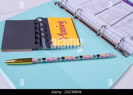 Planungskalender und Stift auf blauem Blatt. Stockfoto
