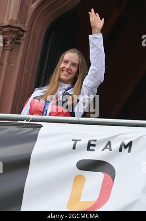 09. August 2021, Hessen, Frankfurt/Main: Radfahrerin Franziska Brauße, Olympiasiegerin im Track Cycling Team Pursuit, winkt vom Balkon des Römer während der Begrüßungszeremonie für das Team Deutschland. Nach dem schwächsten Medaillengewinne seit der Wiedervereinigung ist auch der Rest der Delegation des Deutschen Olympischen Sportbundes von den Olympischen Spielen in Tokio zurückgekehrt. Foto: Arne Dedert/dpa Stockfoto