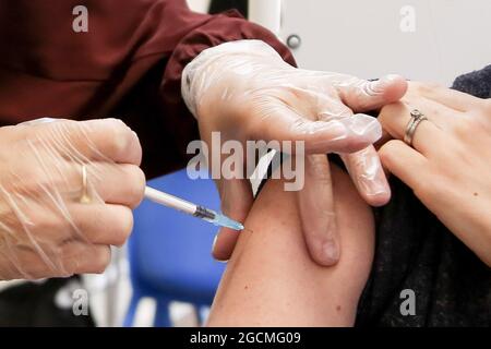 London, Großbritannien. August 2021. Gesundheitshelfer des Gesundheitsdienstes verabreicht einer Frau in einem Impfzentrum in London den Impfstoff Pfizer-BioNTech Covid-19. (Foto: Dinendra Haria/SOPA Images/Sipa USA) Quelle: SIPA USA/Alamy Live News Stockfoto