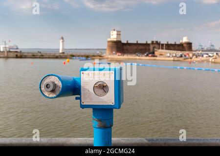 New Brighton, Wirral, Großbritannien: Blaues, münzbetriebenes Eulen-Teleskop am See, mit Blick auf Fort Perch Rock. Hergestellt in Crewe. Stockfoto