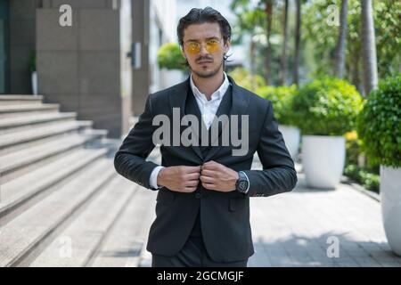 Porträt eines schönen jungen Mannes in schwarzem Anzug und gelbe Sonnenbrille. Hochwertige Fotos Stockfoto