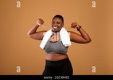 Mollige schwarze Frau in Sportkleidung, die auf sich zeigt Stockfoto