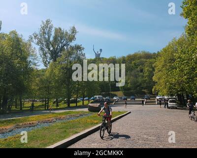Kiew, Ukraine-29. April 2018: Menschen, die Fahrrad fahren und im Nationalmuseum für Geschichte der Ukraine im Komplex des Zweiten Weltkriegs wandern. Mo Stockfoto