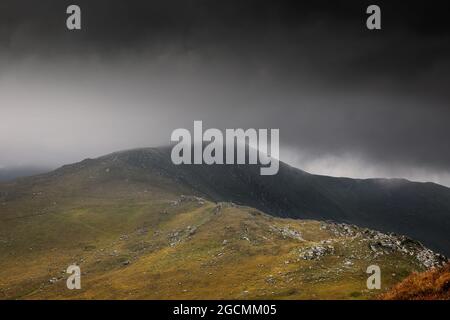 Schlechtes Wetter trifft die österreichischen Nockberge im Sommer. Der Gipfel des Falkert ist bereits von Wolken bedeckt. Einzelne Wanderer sind noch auf den Bergwegen Stockfoto