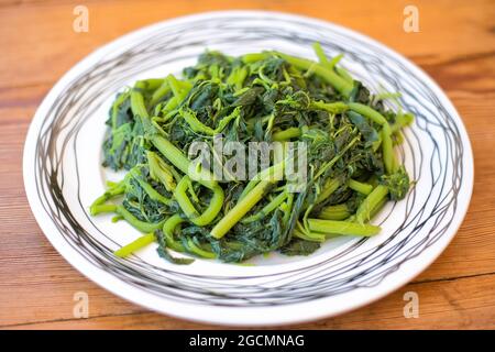 Amaranthus blitum . Vlita Salat auf einem Teller, auf einem alten Holztisch Stockfoto