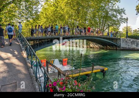 Touristen schlendern auf der Brücke der Liebenden über den Kanal Le Vassè. Annecy, Département Savoie, Region Auvergne-Rhône-Alpes, Frankreich, Europa Stockfoto