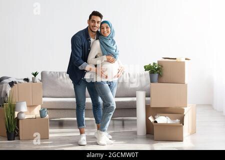 Fröhliches erwartungsvolles Paar, das ein neues Haus kauft, in voller Länge geschossen Stockfoto