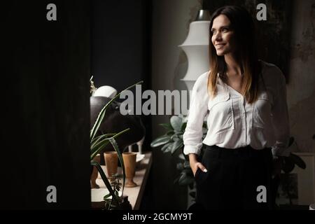 Selbstbewusste, elegante frau im mittleren Alter in europa, die am Arbeitsplatz steht, eine leitende Managerin aus den 30er Jahren im Büro Stockfoto
