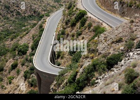 Blick auf Carboneras aus der bergigen Landschaft, kurvige Straße und großes Viadukt. Naturpark Cabo de Gata, Provinz Almería, Spanien. Stockfoto
