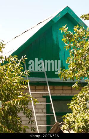 Malen des Giebels des Daches des Hauses. Teilweise bemalter Giebel des Daches des Hauses. Malerei funktioniert Stockfoto
