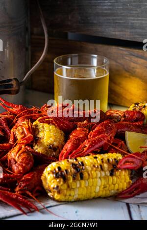 Gedünsteter Krabbelfisch mit gegrilltem Mais und Bier. Stockfoto