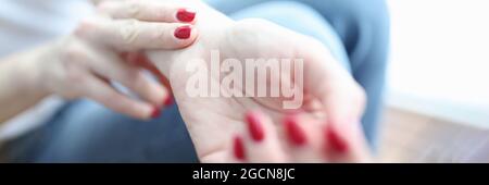 Frau hält die Finger an der Arterie und führt Pulskontrolle durch Stockfoto