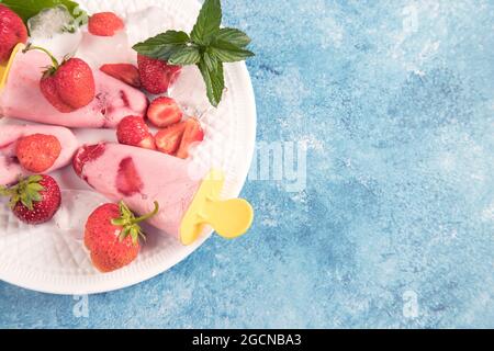 Ein weißer Teller mit hausgemachtem veganen Erdbeereis mit Kokosmilch. Stockfoto