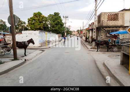LAS TUNAS, KUBA - 27. JANUAR 2016: Zwei Pferdekarrisse überqueren eine Straße in Las Tunas. Stockfoto