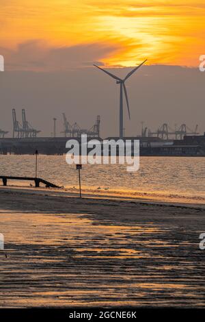 Windturbine in Tilbury Essex, aufgenommen von Gravesend Kent bei Sonnenuntergang. Stockfoto