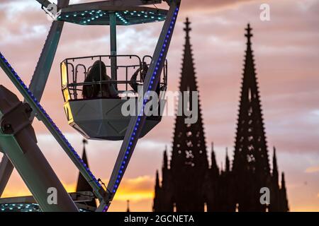 Kirmes Happy Colonia, Corona-konforme Kirmes in der Deutzer Werft, am Rhein, Kölner Dom, Abendrot, Riesenrad, Eine temporäre Unterhaltung pa Stockfoto