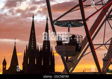 Kirmes Happy Colonia, Corona-konforme Kirmes in der Deutzer Werft, am Rhein, Kölner Dom, Abendrot, Riesenrad, Eine temporäre Unterhaltung pa Stockfoto