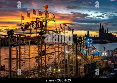 Kirmes Happy Colonia, Corona-konforme Kirmes in der Deutzer Werft, am Rhein, Kölner Dom, Abendrot, Achterbahn Wilde Maus, eine temporäre Stockfoto