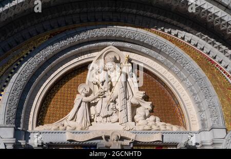 LOURDES, FRANKREICH - 12. Oktober 2020: Tympanon des Hauptportals der Basilika Unsere Liebe Frau vom Rosenkranz, Lourdes, Frankreich. Jungfrau Maria und Baby Jesus h Stockfoto