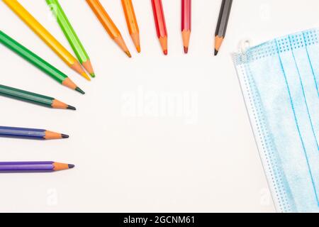 título: Zurück zur Schule 2021, Bleistifte und Covid19 Maske. Weißer Hintergrund mit Platz für Text. Horizontale Fotografie. Stockfoto