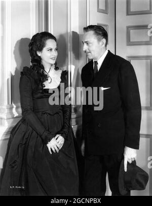 MERLE OBERON mit Set-Besucher JOHN BARRYMORE am Set offen während der Dreharbeiten ZUM SCHARLACH PIMPERNEL 1934 Regisseur HAROLD JUNGES Buch Baroness Orczy Miss Oberons Kleider Oliver Messel Produzent Alexander Korda London Film Productions / United Artists Stockfoto