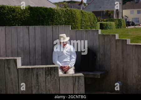 Ein Mann, der sich auf einer Bank am Porthcressa Beach, St. Mary's Island, Isles of Scilly, Cornwall, England, Großbritannien, Juli 2021 Stockfoto