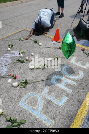 Ferguson, Usa. August 2021. Am Montag, den 9. August 2021, kniet eine Frau am Ort des Todes von Michael Brown Jr. zum siebenjährigen Jubiläum in Ferguson, Missouri, nieder.Brown Jr. (18) wurde 2014 vom Ferguson-Polizeibeamten Darren Wilson angeschossen und getötet. Nach einer Auseinandersetzung folgte, als Brown Wilson in seinem Polizeifahrzeug zur Kontrolle von Wilsons Waffe angriff, bis es abgefeuert wurde. Foto von Bill Greenblatt/UPI Credit: UPI/Alamy Live News Stockfoto