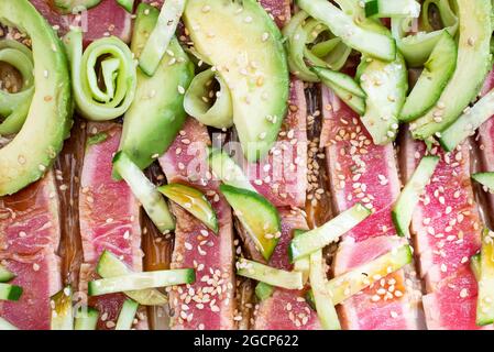 Nahaufnahme eines angebratenen Thunfischs mit Sesamsamen, Gurke und Avocadi Stockfoto