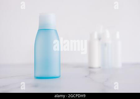 Low tox und ungiftige natürliche Beauty-Produkte konzeptuelles Bild, blaue Lotion Flasche im Vordergrund, die sich von der Gruppe anderer Flaschen absetzt Stockfoto