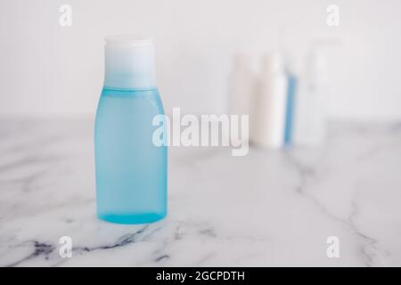 Low tox und ungiftige natürliche Beauty-Produkte konzeptuelles Bild, blaue Lotion Flasche im Vordergrund, die sich von der Gruppe anderer Flaschen absetzt Stockfoto