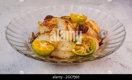 Eingelegter Rambutan mit Calamansi, saurer Pflaume und Vogelaugen-Chili. Isolierte Profilaufnahme. Stockfoto