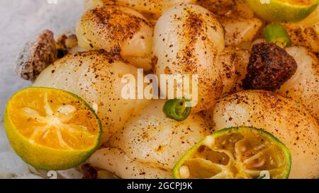 Eingelegter Rambutan mit Calamansi, saurer Pflaume und Vogelaugen-Chili. Nahaufnahme mit selektivem Fokus. Stockfoto