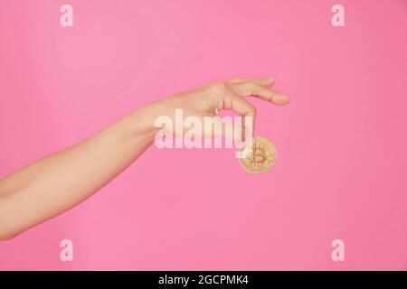 Handy, Münze, Clip, wachsen, Bitcoin. Kommunizieren Sie positiv und rational, die Bitcoins werden mit zwei Fingern gehalten. Stockfoto