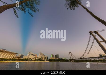 Sonnenuntergang über der Stadt Putrajaya, Malaysia. Blauer Himmel fällt in die Nacht. Romantische Atmosphäre auf dem See in Putrajaya. Die Skyline im goldenen li Stockfoto