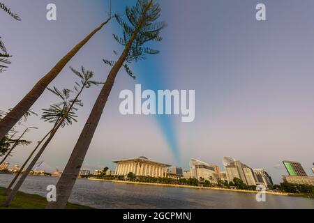 Sonnenuntergang über der Stadt Putrajaya, Malaysia. Blauer Himmel fällt in die Nacht. Romantische Atmosphäre auf dem See in Putrajaya. Die Skyline im goldenen li Stockfoto