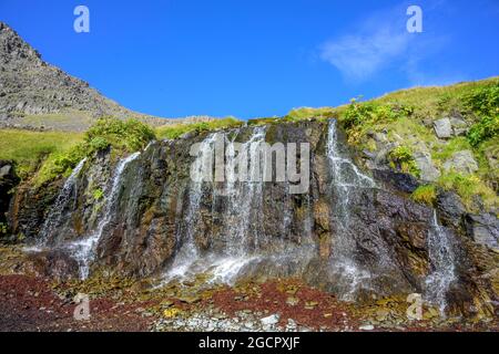 Bucht mit breitem Wasserfall, Rauoasandur, Patreksfjoerour, Vestfiroir, Island Stockfoto