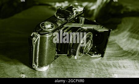 Leipzig, Sachsen, Deutschland - 1. Oktober 2020: Alte zerkratzte und staubige Fotokamera, mit klappbarem original Carl Zeiss Objektiv, stehend auf einem antikem Holz Stockfoto