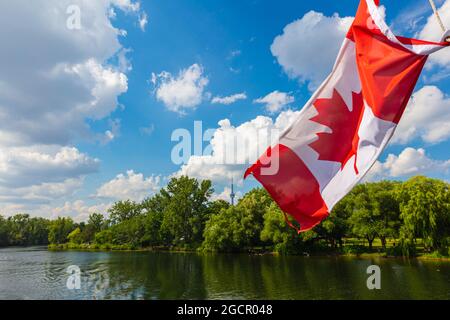 Kanadische Flagge auf einem Kreuzfahrtboot auf den Inseln rund um die Stadt Toronto. Die rot-weiße Flagge Kanadas mit dem Ahornblatt in der Mitte. Die CN Stockfoto