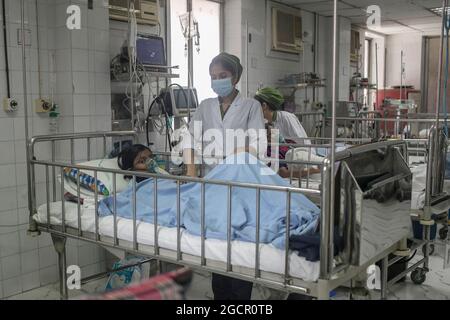 Dhaka, Bangladesch. August 2021. Eine Krankenschwester sorgt im Kinderkrankenhaus für ein Mädchen, das mit Dengue infiziert wurde. Bangladesch kämpft gegen Dengue-Ausbruch Angesichts der COVID-Krise belastet eine scharfe Spitze der Dengue-Fälle das Gesundheitssystem von Bangladesch, das bereits von einer sich verschärfenden COVID-Krise im Land angesteckt wurde. In diesem Monat wurde bei 1,920 Personen die durch Moskitos übertragene Krankheit diagnostiziert, was einer Zunahme der Dengue-infizierten Patienten von Juni auf 272 Fälle Anstieg. Dhaka, Bangladesch, 8. August 2021. Foto von Sazzad Hossain/Eyepix/ABACAPRESS.COM Quelle: Abaca Press/Alamy Live News Stockfoto