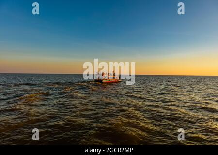 Sonnenuntergang am Tonle SAP See, Kambodscha, in der Nähe des schwimmenden Dorfes Kampong Phluk und Siem Reap. Tourismusboote, die auf dem Wasser fahren, um die atemtaki zu genießen Stockfoto