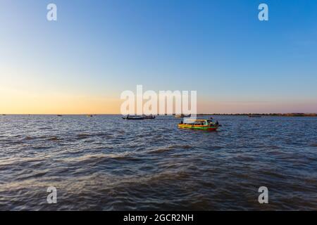 Sonnenuntergang am Tonle SAP See, Kambodscha, in der Nähe des schwimmenden Dorfes Kampong Phluk und Siem Reap. Tourismusboote, die auf dem Wasser fahren, um die atemtaki zu genießen Stockfoto